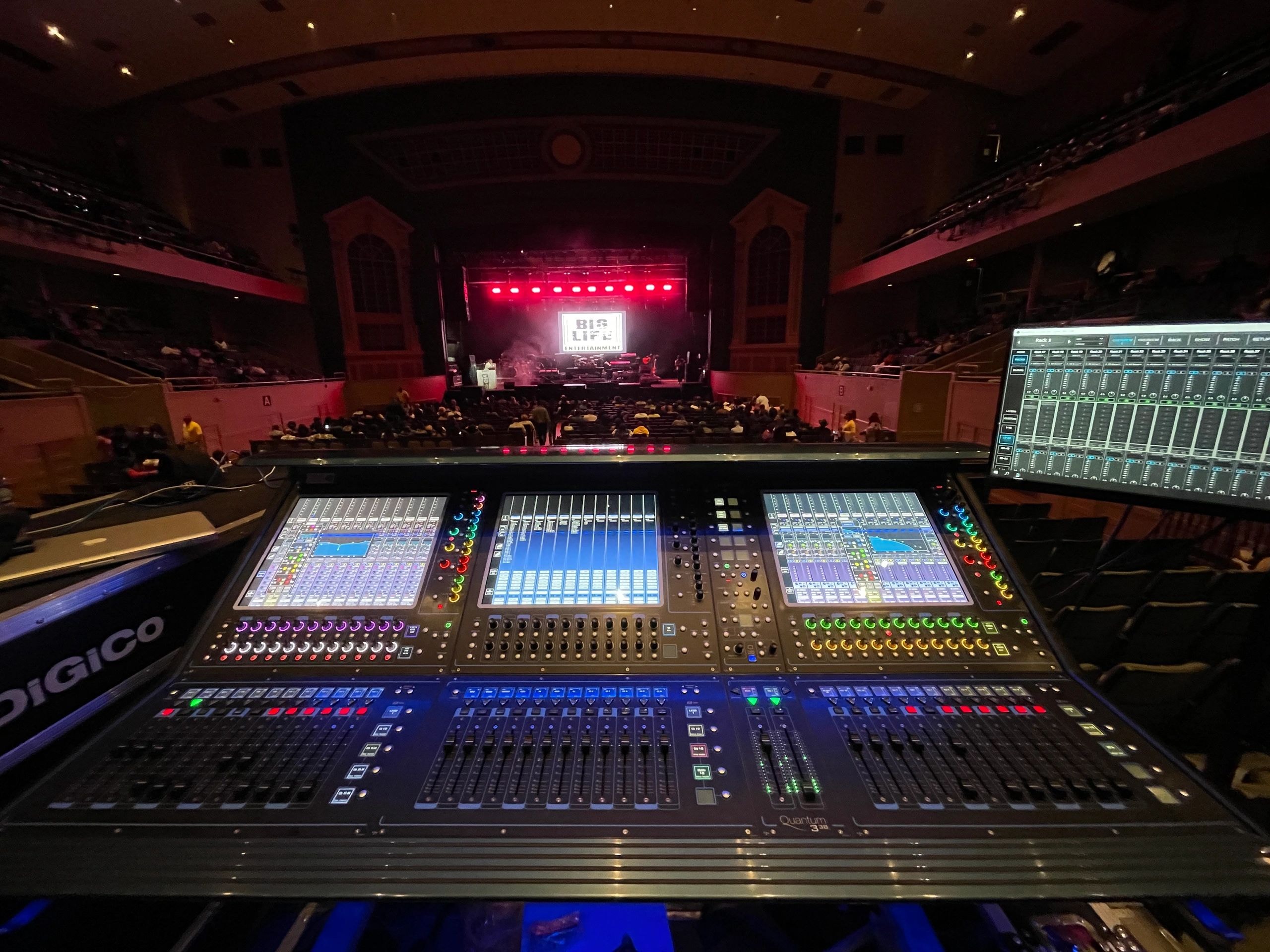 Live concert production — mixing console and stage